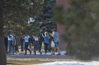 Students walk with their hands raised as they are escorted out of Arapahoe High School, after a student opened fire in the school in Centennial, Colorado December 13, 2013. The student seeking to confront one of his teachers opened fire at the Colorado high school on Friday, wounding at least two classmates before apparently taking his own life, law enforcement officials said. REUTERS/Evan Semon (UNITED STATES - Tags: EDUCATION CRIME LAW)