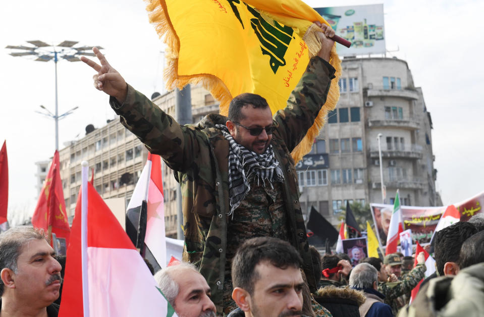 A member of the Syrian military waves a flag of Lebanon's Shiite Hezbollah movement in the central Saadallah al-Jabiri square in the northern Syrian city of Aleppo on January 7, 2020, to mourn and condemn the death of Iranian military commander Qasem Soleimani, and nine others in a US air strike in Baghdad. (Photo by - / AFP) (Photo by -/AFP via Getty Images)