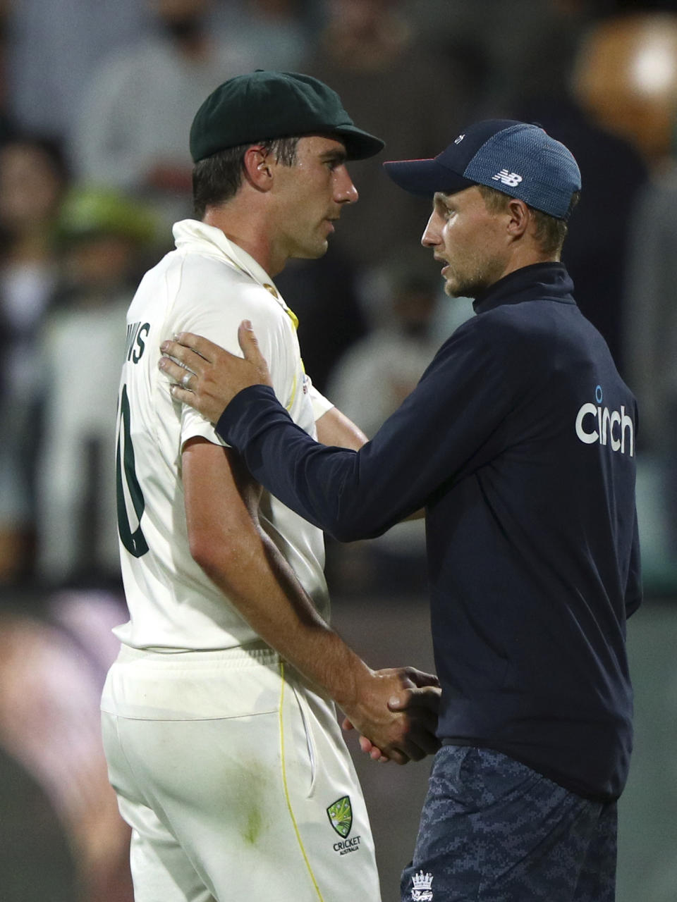 Australia's captain Pat Cummins, left, shakes hands with England's captain Joe Root after their Ashes cricket test match in Hobart, Australia, Sunday, Jan. 16, 2022. Australia won the matcha and the series. (AP Photo/Tertius Pickard)