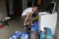 Christopher Bagay, a kitchen crew of the Aida Sol cruise ship in Europe, takes off his socks as he does laundry upon arriving at his home in Laguna province, south of Manila, Philippines Thursday, May 28, 2020. Bagay said it took him about two months to go through repetitive quarantines in Spain, Germany and Manila before he was finally allowed to go home. Tens of thousands of workers have returned by plane and ships as the pandemic, lockdowns and economic downturns decimated jobs worldwide in a major blow to the Philippines, a leading source of global labor. (AP Photo/Aaron Favila)