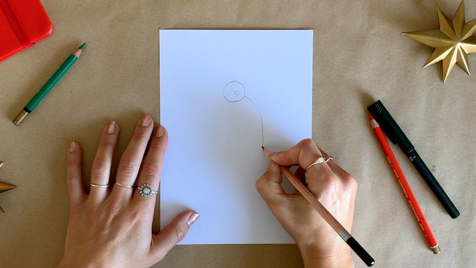 a person drawing santa on a white piece of paper