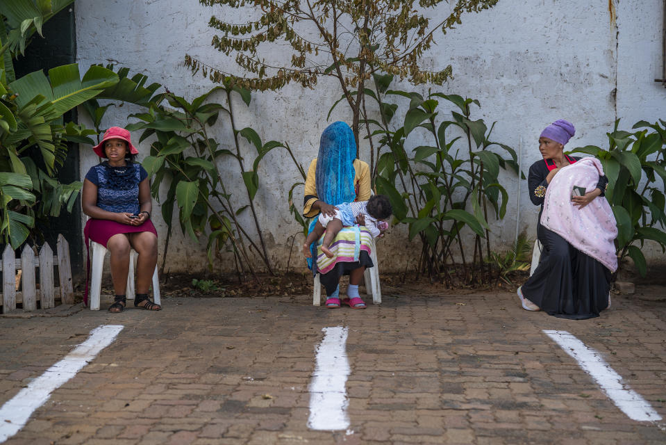 Tres mujeres reciben golosinas del Ramadán en la mezquita Imán Ahmed Raza Jaame Masjid en Springes, cerca de Johanesburgo, Sudáfrica, 23 de abril de 2020. (AP Foto/Jerome Delay)