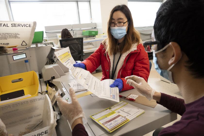 STOCKTON CA MARCH 11, 2024 - Haley Pau unfolds ballots after the envelopes have been opened and sorted at the San Joaquin County Registrar office on Monday morning in downtown Stockton, California on March 11, 2024. (Jose Luis Villegas / For The Times)