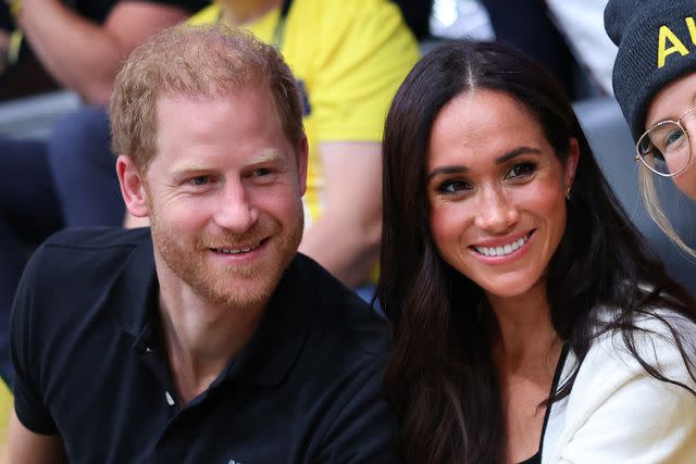 <p>Chris Jackson/Getty</p> Prince Harry and Meghan Markle smile in the stands at the 2023 Invictus Games.