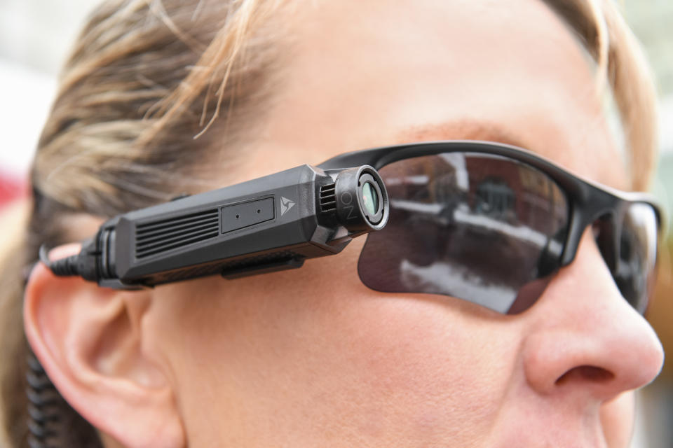 A person wearing the Axon Flex 2 camera attached to their sunglasses.