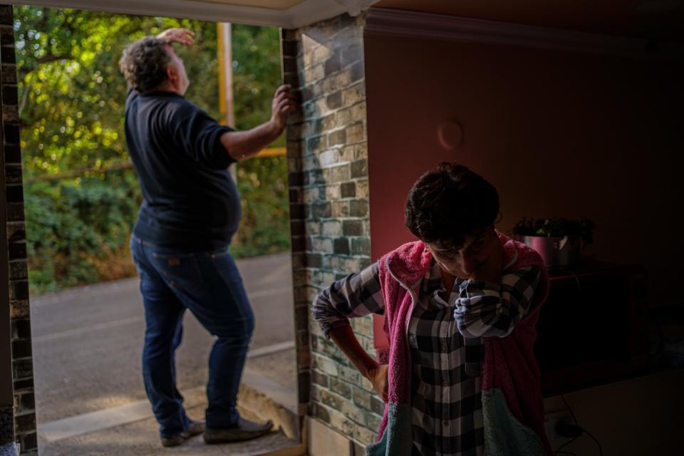 A man peers outside next to a woman taking shelter in a basement in Karmir Shuka, Nagorno-Karabakh.