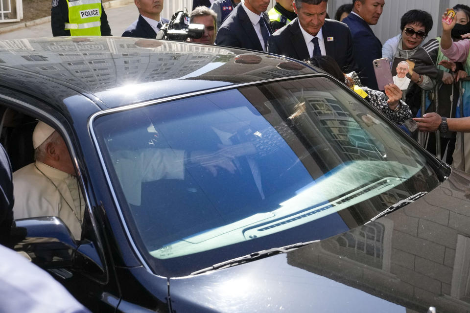 A faithful reaches for Pope Francis' hand as he leaves in a car after a meeting with charity workers and the inauguration of the House of Mercy in Ulaanbaatar, Monday, Sept. 4, 2023. Francis toured the House of Mercy in the final event of an historic four-day visit to a region where the Holy See has long sought to make inroads. (AP Photo/Ng Han Guan)