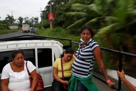 Eufemia Garcia, 48, who lost 50 members of her family during the eruption of the Fuego volcano, takes a ride with other residents after a day spent searching for her family in Escuintla, Guatemala, June 13, 2018. REUTERS/Carlos Jasso