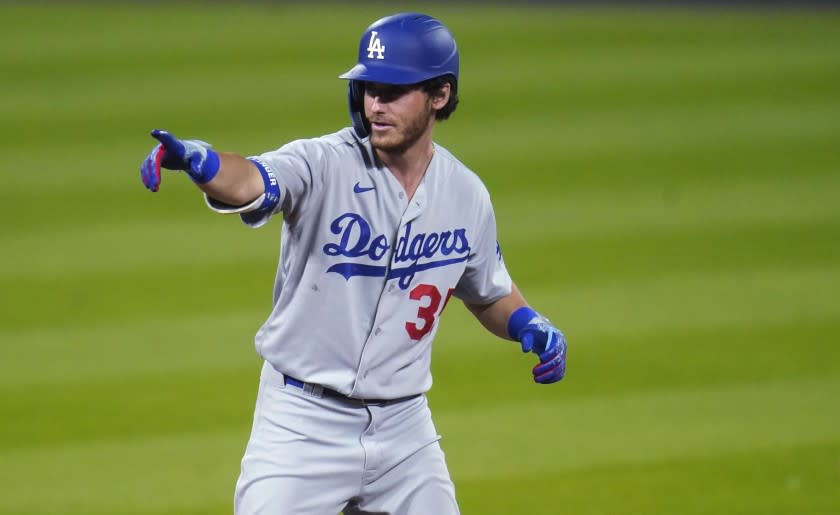 Los Angeles Dodgers' Cody Bellinger gestures to the dugout after pulling into second base with a double off Colorado Rockies relief pitcher Wade Davis to lead off seventh inning of a baseball game Friday, Sept. 18, 2020, in Denver. The Dodgers won 15-6. (AP Photo/David Zalubowski)