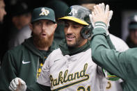 Oakland Athletics designated hitter Abraham Toro is greeted in the dugout after a solo home run during the seventh inning of a baseball game against the Detroit Tigers, Friday, April 5, 2024, in Detroit. (AP Photo/Carlos Osorio)