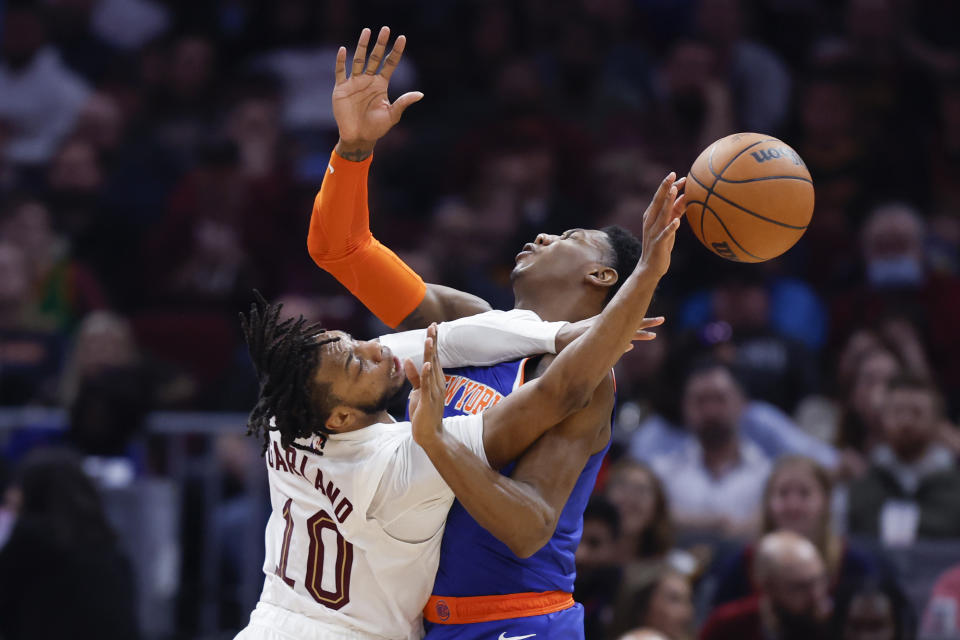 Cleveland Cavaliers guard Darius Garland (10) passes the ball against New York Knicks guard RJ Barrett during the second half of an NBA basketball game, Friday, March 31, 2023, in Cleveland. (AP Photo/Ron Schwane)