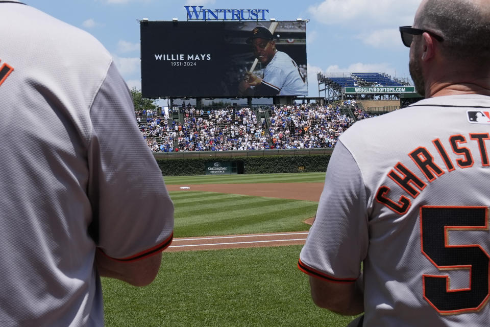 Fans and San Francisco Giants coaching staff stand for a moment of silence for Willie Mays before a baseball game between the Giants and the Chicago Cubs in Chicago, Wednesday, June 19, 2024. Mays died Tuesday. (AP Photo/Nam Y. Huh)