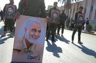 A member of the Hashed al-Shaabi, an Iraqi paramilitary network dominated by Iran-backed factions, carries a portrait of Soleimani