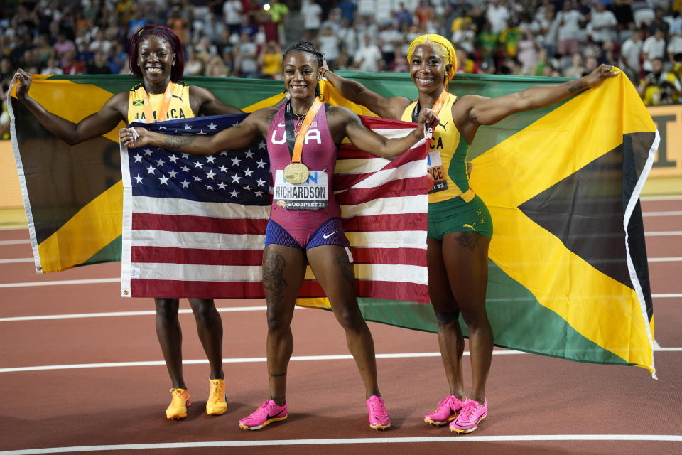 Silver medalist Shericka Jackson, of Jamaica, gold medalist Sha'Carri Richardson, of the United States, and bronze medalist Shelly-Ann Fraser-Pryce, of Jamaica, from left, pose after the Women's 100-meter final during the World Athletics Championships in Budapest, Hungary, Monday, Aug. 21, 2023.(AP Photo/Bernat Armangue)