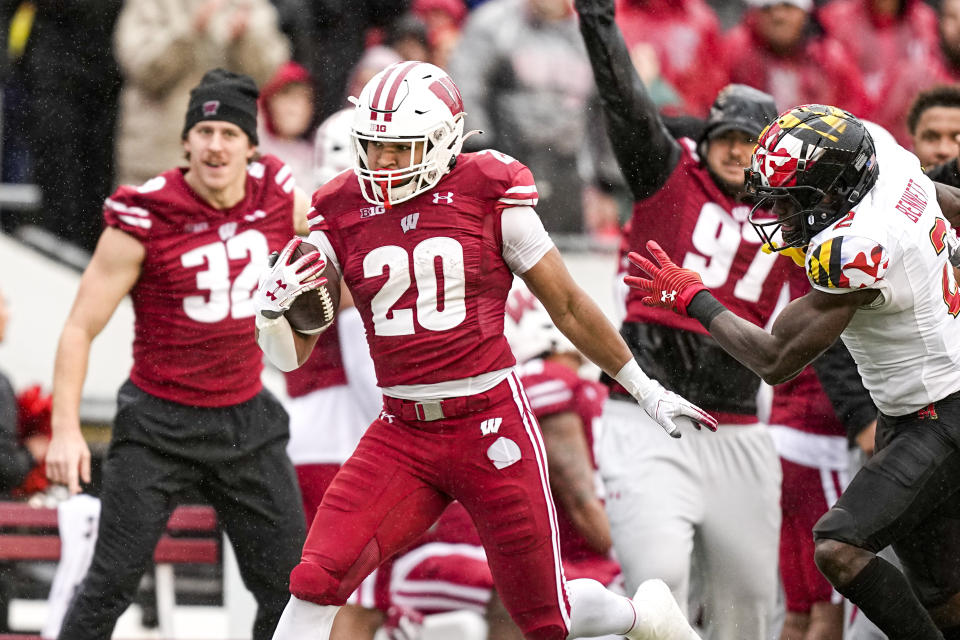 Wisconsin running back Isaac Guerendo (20) runs for an 89-yard touchdown run past Maryland defensive back Jakorian Bennett (2) during the first half of an NCAA college football game Saturday, Nov. 5, 2022, in Madison, Wis. (AP Photo/Andy Manis)