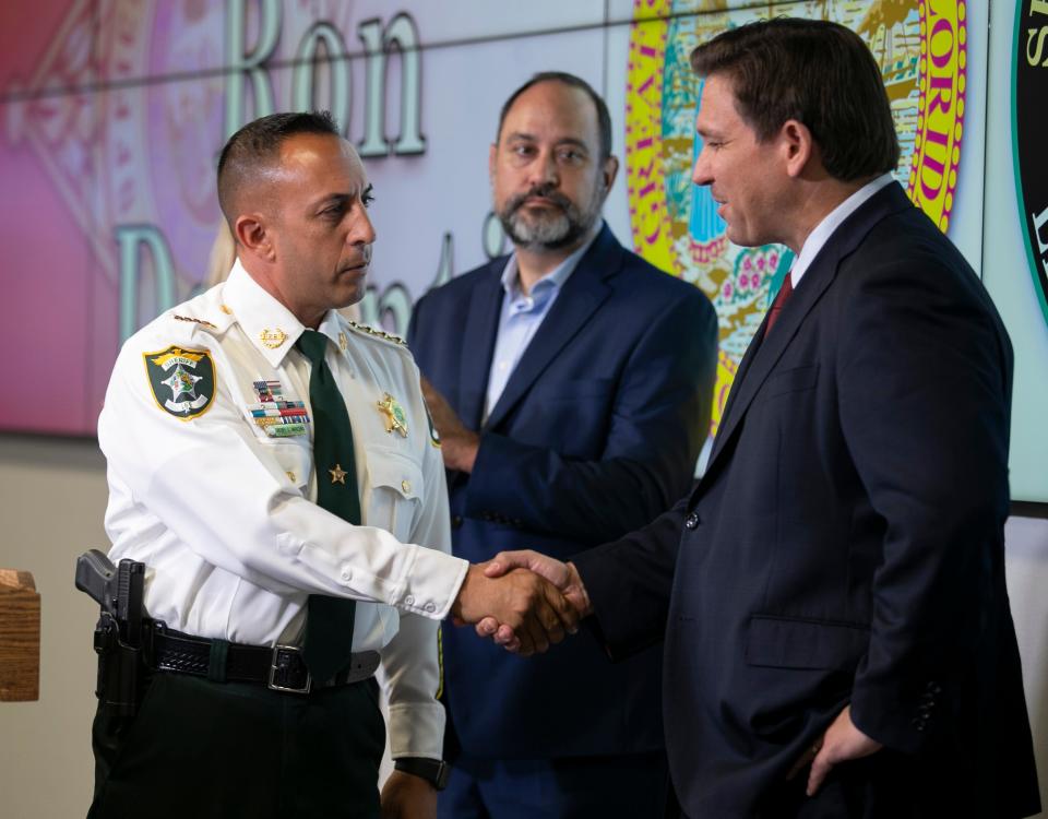 Sheriff Carmine Marceno shakes hands with Gov. Ron DeSantis after DeSantis announced $1,000 bonuses for first responders at a press conference at the Lee County Sheriff's Office on Wednesday in Fort Myers, Fla.