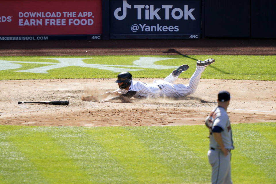 Houston Astros relief pitcher Ryan Pressly, foreground, watches as New York Yankees' Gleyber Torres scores on Aaron Hick's infield single during the eighth inning of a baseball game, Thursday, May 6, 2021, at Yankee Stadium in New York. (AP Photo/Kathy Willens)
