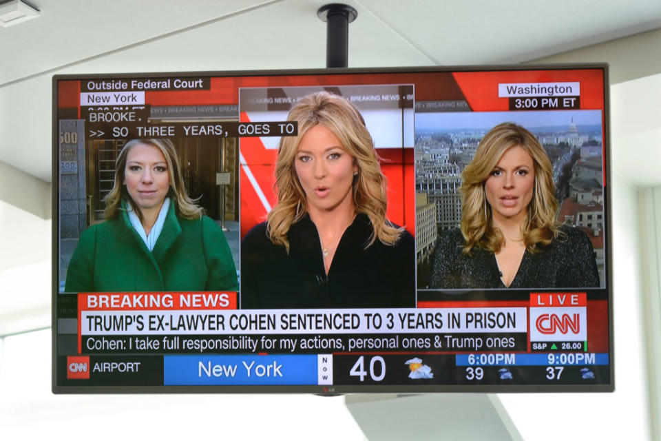 TV screen displaying CNN news with three reporters presenting a story about Donald Trump's ex-lawyer's sentencing