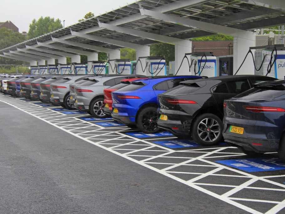 A row of vehicles each plugged into an electric vehicle charger.
