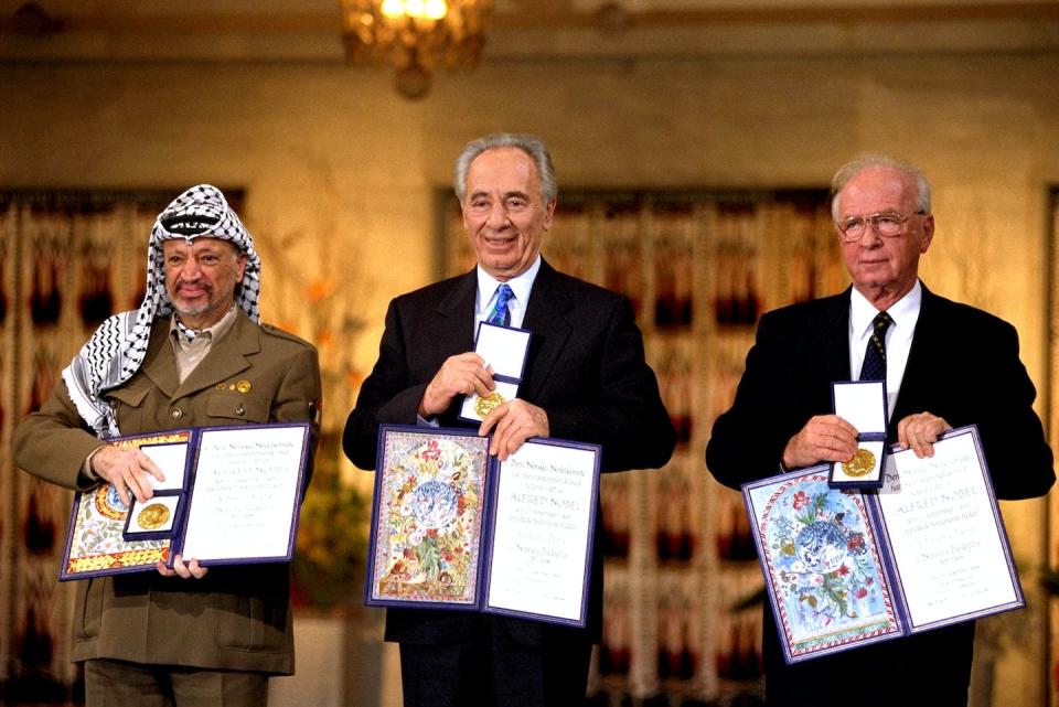 Palestinian leader Yaser Arafat, left, Israeli Foreign Minister Shimon Peres, center, and Israeli Prime Minister Yitzak Rabin display their joint Nobel Peace Prizes in 1994. <a href="https://www.gettyimages.com/detail/news-photo/in-this-handout-from-the-government-press-office-israeli-news-photo/51663003?adppopup=true" rel="nofollow noopener" target="_blank" data-ylk="slk:Government Press Office via Getty Images;elm:context_link;itc:0;sec:content-canvas" class="link ">Government Press Office via Getty Images</a>