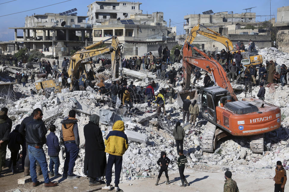 Rescuers and residents search through the rubble of collapsed buildings in the town of Harem near the Turkish border, Idlib province, Syria, Wednesday, Feb. 8, 2023. With the hope of finding survivors fading, stretched rescue teams in Turkey and Syria searched Wednesday for signs of life in the rubble of thousands of buildings toppled by a catastrophic earthquake. (AP Photo/Ghaith Alsayed)