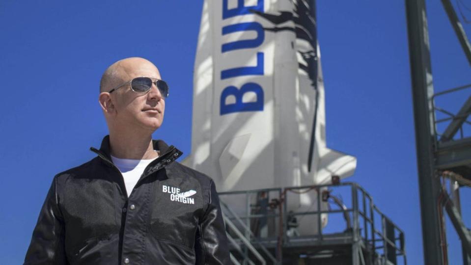 Amazon-Mitbegründer Jeff Bezos neben einer Rakete, die von seinem Raumfahrtunternehmen Blue Origin entwickelt wurde.