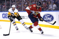 Florida Panthers left wing Anthony Duclair (10) loses the puck to Pittsburgh Penguins defenseman Brian Dumoulin (8) during the second period of an NHL hockey game Thursday, Oct. 14, 2021, in Sunrise, Fla. (AP Photo/Lynne Sladky)