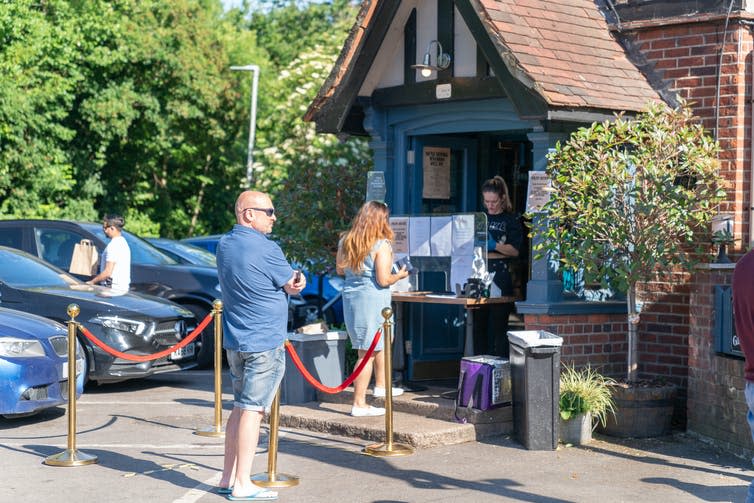 People queuing outside a pub.