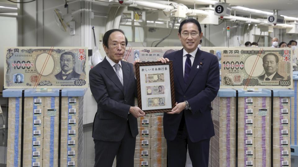 Japanese Prime Minister Fumio Kishida, right, and Bank of Japan Governor Kazuo Ueda hold the country’s new banknotes in a frame, during a ceremony to mark the release of the banknotes, at the BOJ headquarters in Tokyo, Japan, Wednesday, July 3, 2024. (Japan Pool/Kyodo News via AP)