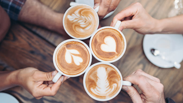 Hands holding coffee different foam designs