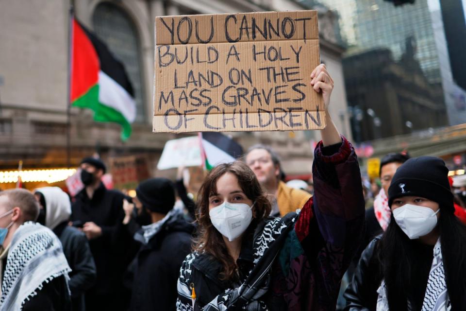 A person holds up a sign during a Pro-Palestine march to participate in a Global Strike for Gaza on 18 December 2023 in New York City, New York (Getty Images)