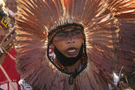 An Indigenous man takes part in a ritual during the "Luta pela Vida," or Struggle for Life mobilization, a protest to pressure Supreme Court justices who are expected to issue a ruling that will have far-reaching implications for tribal land rights, outside the Supreme Court in Brasilia, Brazil, Wednesday, Aug. 25, 2021. (AP Photo/Eraldo Peres)