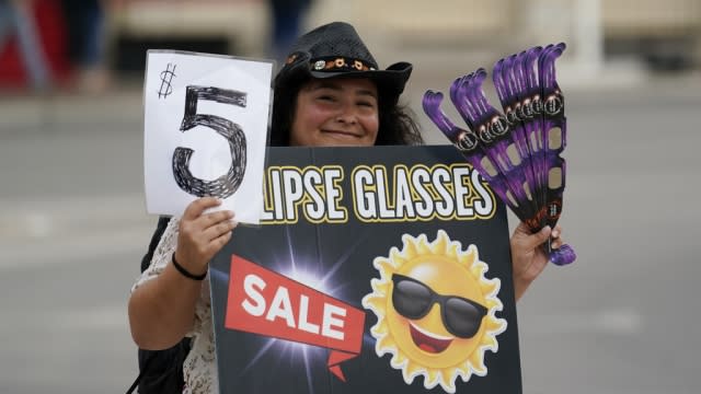 A vendor sells special glasses to view an annular solar eclipse.