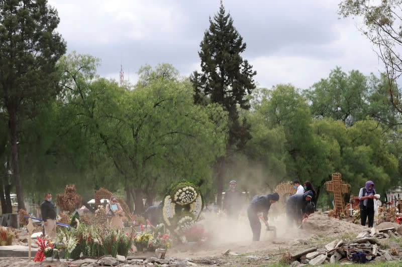 Family members look on during the burial of their relative who died of the coronavirus disease (COVID-19) in Mexico City