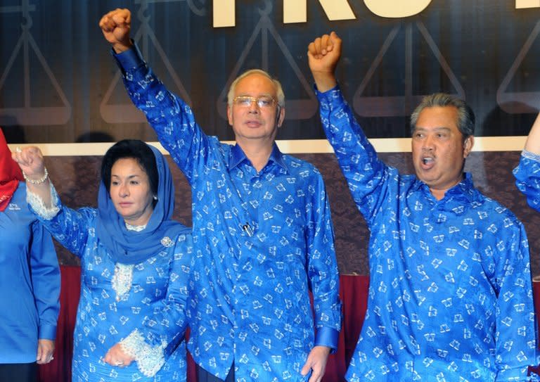 Malaysian Prime Minister Najib Razak (centre), his wife Rosmah Mansor (left) and Deputy Prime Minister Muhyiddin Yassin celebrate the Barisan Nasional coalition's election victory on May 6, 2013 in Kuala Lumpur. Razak was sworn in for a second term by Malaysia's king on Monday, after his 56-year-old ruling coalition retained power in elections branded as fraudulent by the opposition