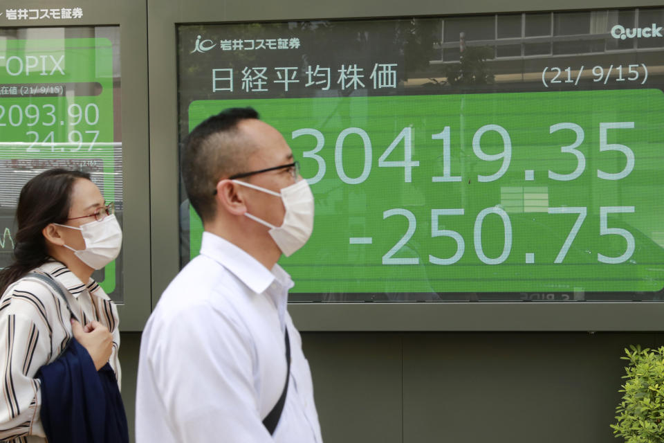 People walk by an electronic stock board of a securities firm in Tokyo, Wednesday, Sept. 15, 2021. Asian stock markets followed Wall Street down on Wednesday after U.S. inflation was lower than expected amid unease about the impact of the spread of the coronavirus's delta variant. (AP Photo/Koji Sasahara)