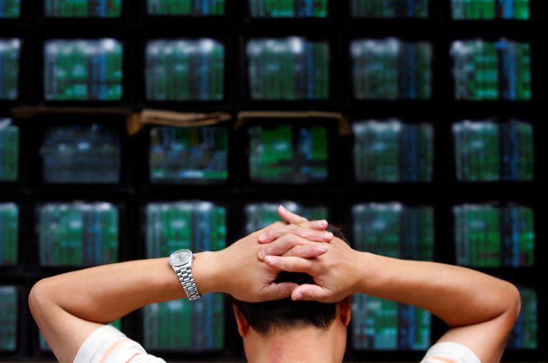 FILE PHOTO: A man looks at stock market monitors in Taiwan