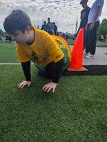 Joey DeMarco, a 13-year-old student at Stark County Learning Center, crawls out of a tunnel during an obstacle course at the Exceptional Olympics.