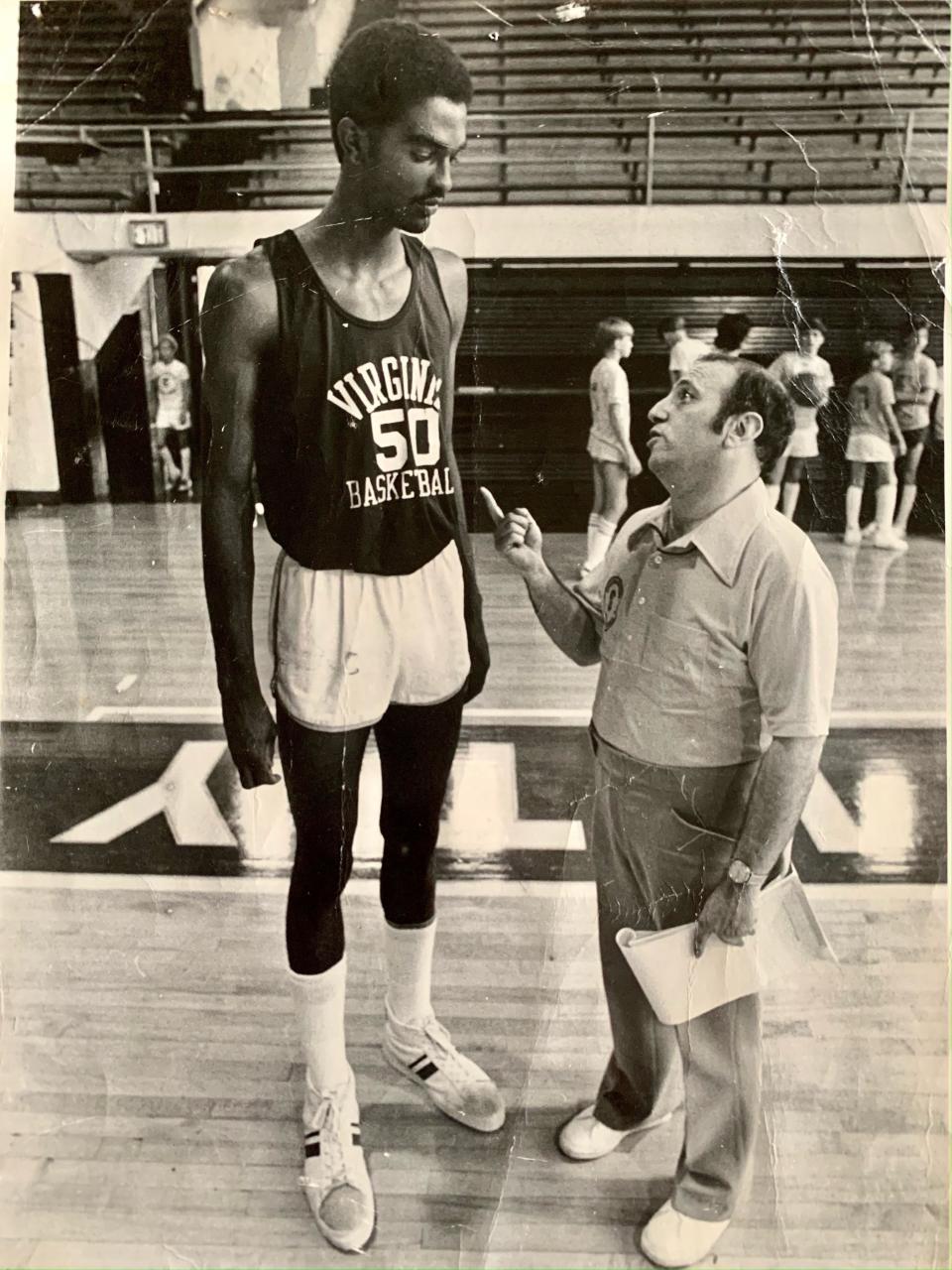 Glen Korobov has some coaching pointers for Virginia's 7-4 Ralph Sampson, a three-time national player of the year, at a summer camp.