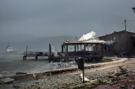 Waves break on a seaside tavern during a storm at the port of Argostoli, on the Ionian island of Kefalonia, western Greece, Friday, Sept. 18, 2020. A powerful tropical-like storm named Ianos battered the western islands of Zakynthos, Kefalonia, and Ithaki overnight, causing flash flooding, property damage, power outages, and road closures mostly from downed trees, police and local authorities said. (AP Photo/Nikiforos Stamenis)