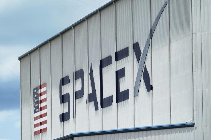 FILE - The SpaceX logo is displayed on a building, Tuesday, May 26, 2020, at the Kennedy Space Center in Cape Canaveral, Fla. Several SpaceX employees who were fired after circulating an open letter calling out CEO Elon Musk's behavior have filed a complaint accusing the company of violating labor laws. The complaint, made Wednesday, Nov. 16, 2022, to the National Labor Relations Board, says five employees who participated in organizing the June letter were fired a day after the letter was sent to company executives. (AP Photo/David J. Phillip, File)