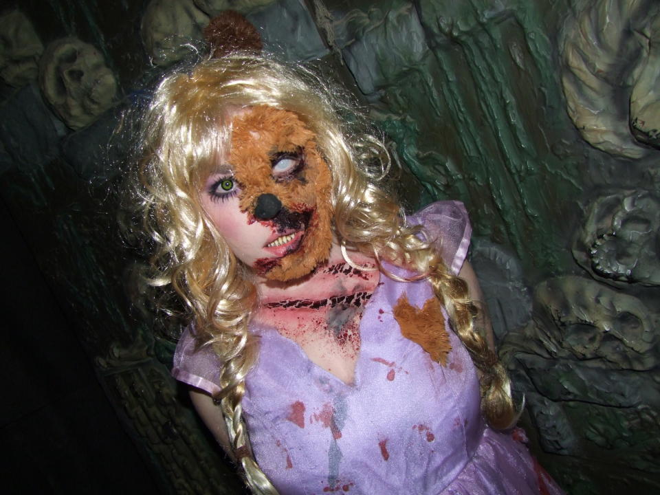 A woman with her face spliced into a teddy bear approaches guests at "Spookers"