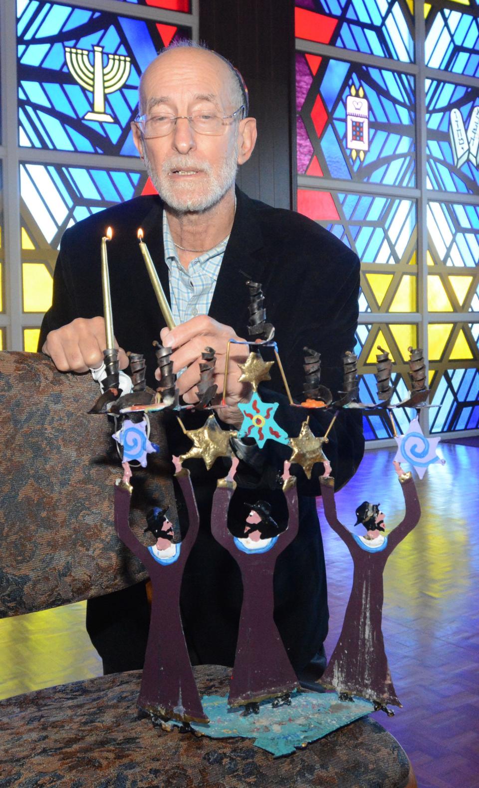 Rabbi Ken Alter lights the first candle of Hanukkah at Congregation Ahavath Achim in Colchester. Rabbi Alter is in his 25th year at the Lebanon Avenue synagogue.