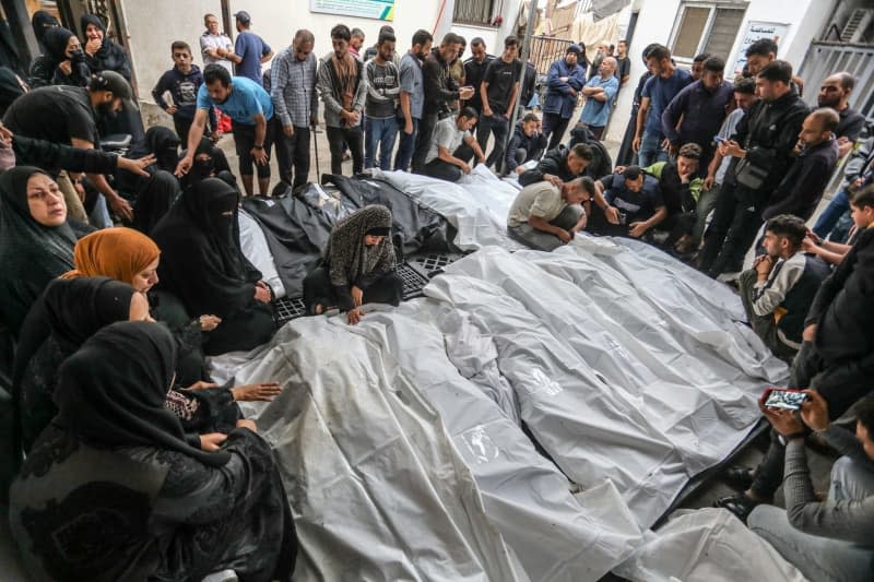 Palestinians gather around their dead relatives and loved ones, who were killed in Israeli air strikes to mourn them at Al Najjar hospital. Abed Rahim Khatib/dpa