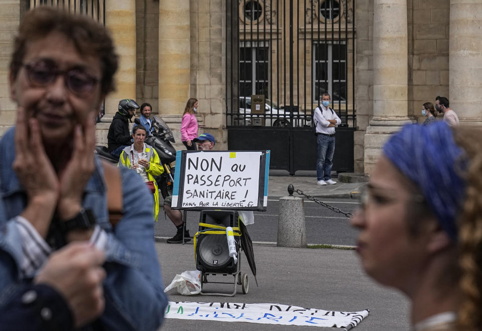 Anti heath pass demonstrators stage a protest outside the Constitutional Council in Paris, Thursday, Aug. 5,2021. France's Constitutional Council is deciding on Thursday whether the health pass that is to open the doors and terraces to cafes, restaurants, trains and hospitals starting next week is in line with the nation's most cherished principles. (AP Photo/Michel Euler)