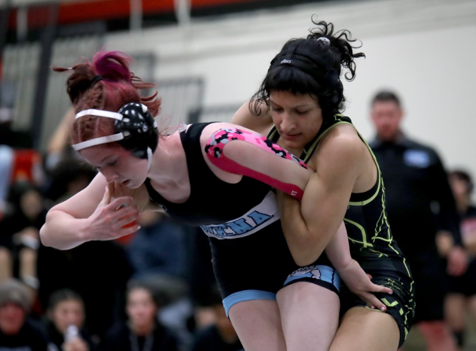 Buena's Lily Bossoletti (left) and Ventura's Reagan Monsour battle out during the Channel League wrestling finals at Rio Mesa High on Saturday. Monsour won the 121-pound title while Bossoletti finished second.