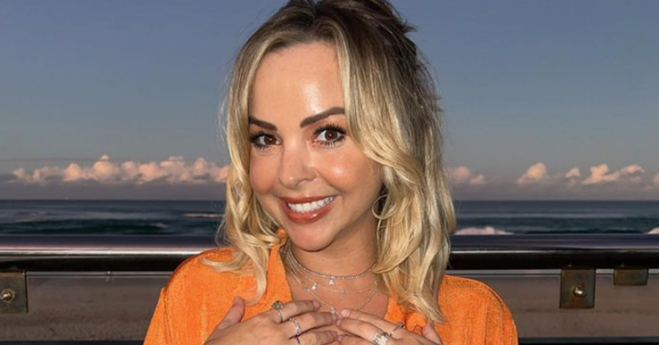 Angie Kent smiles while wearing an orange shirt. 