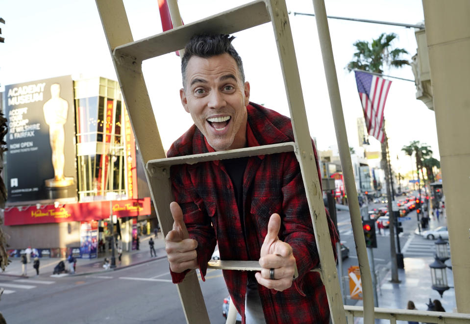 Steve-O, a cast member in the film "Jackass Forever," poses for a portrait on a fire escape above Hollywood Blvd. at the Hollywood Roosevelt in Los Angeles on Jan. 27, 2022. (AP Photo/Chris Pizzello)