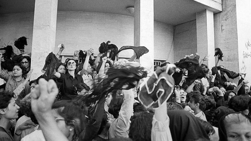 A group of women protest against wearing the Islamic veil, while waving their veils in the air outside the office of the Prime Minister, Tehran, Iran, 6th July 1980