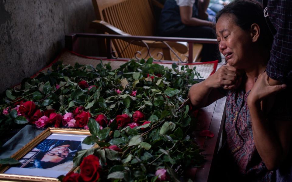 A woman cries near a portrait of Lin Htet, who was killed in an anti-coup protest and his body was taken by military, March 12 - Reuters